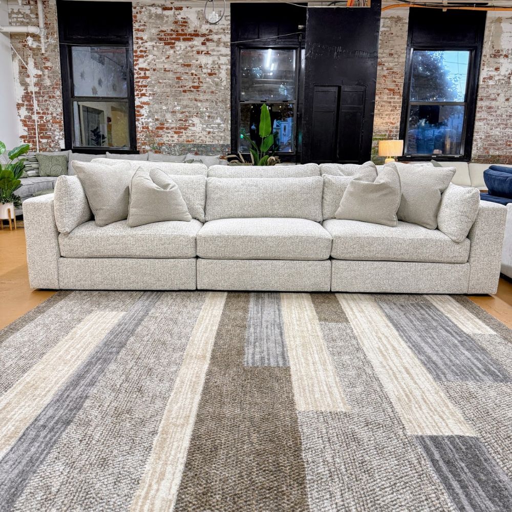 Ashley Furniture Alpine 3-piece sectional sofa with plush cushions and modern design, shown in a spacious living room setting.