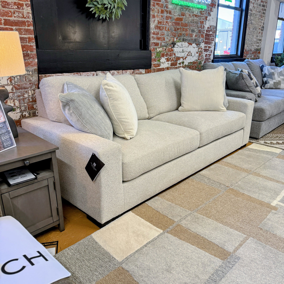 Ashley Furniture Hudson sofa with plush fabric upholstery and cushioned armrests, shown in a stylish living room setting.