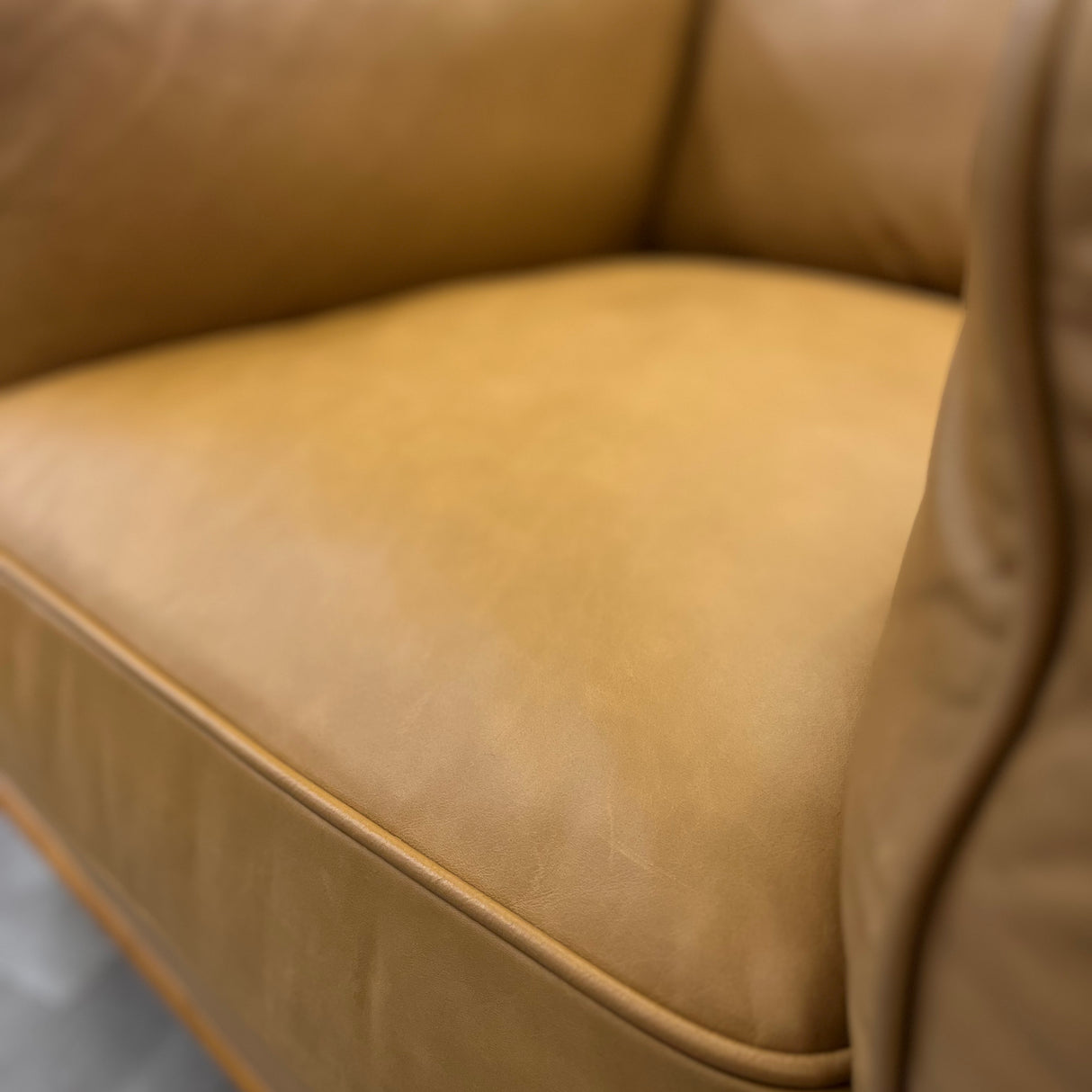 Leather MCM lounge chair in Charme Tan with sleek design and wooden legs, showcasing a stylish and comfortable seating option.