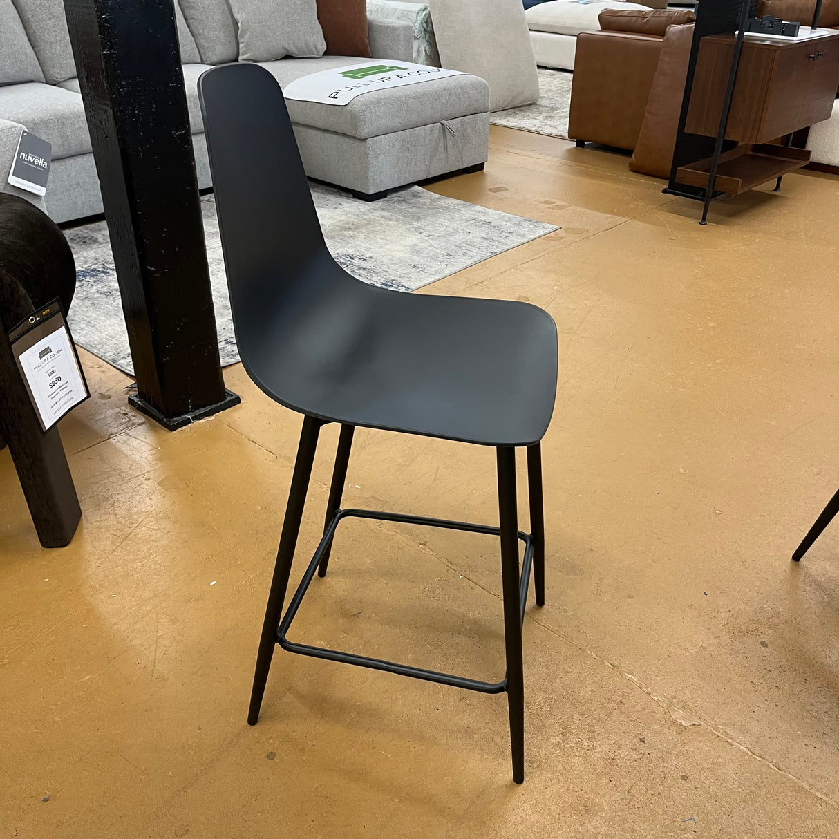 Black MCM counter height barstool by Article with sleek design and sturdy legs, perfect for modern kitchen or bar area.