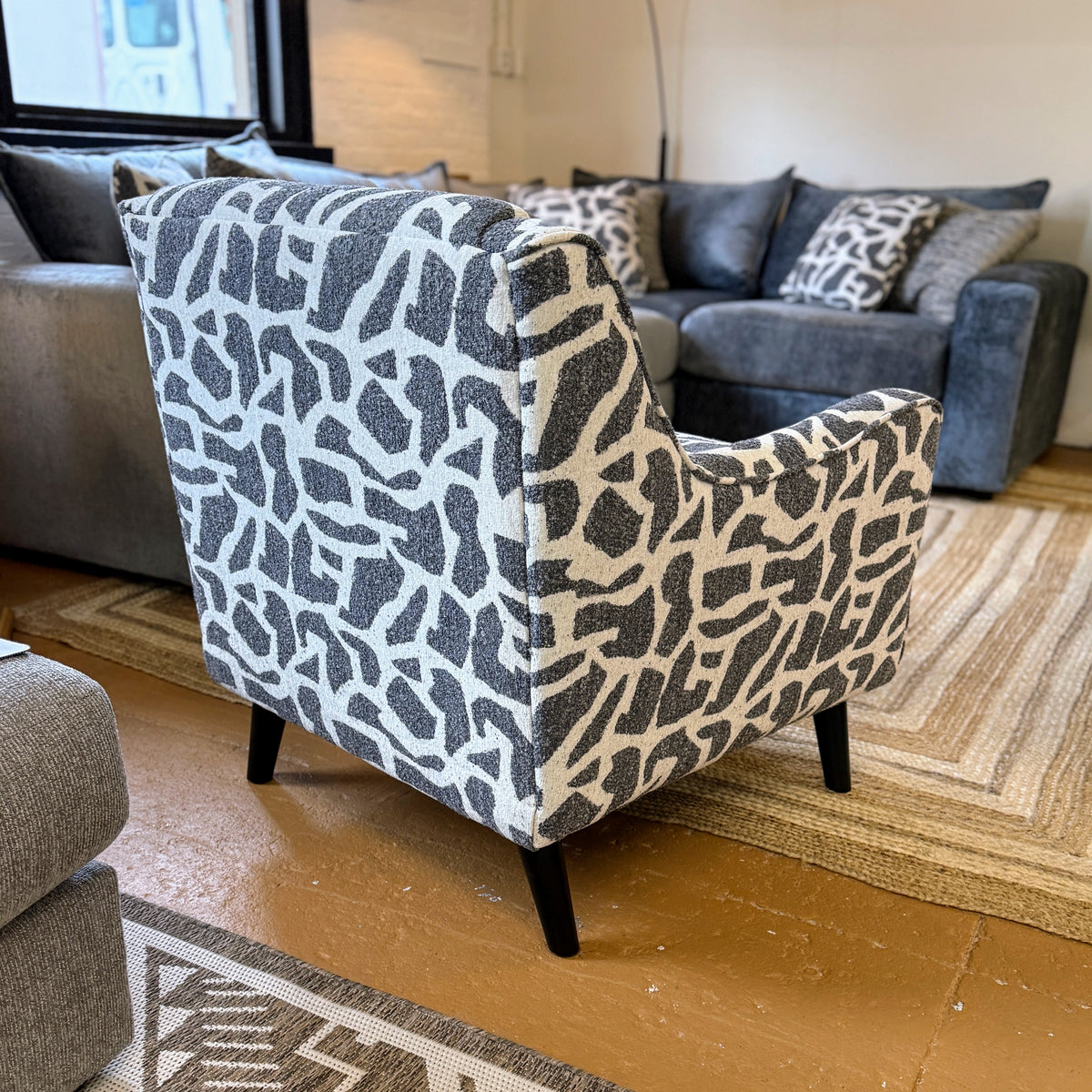 Fusion Barrington Accent Chair with plush fabric upholstery and wooden legs, shown in a cozy living room setting.