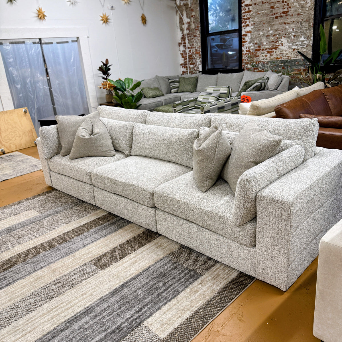 Ashley Furniture Alpine 3-piece sectional sofa with plush cushions and modern design, shown in a spacious living room setting.