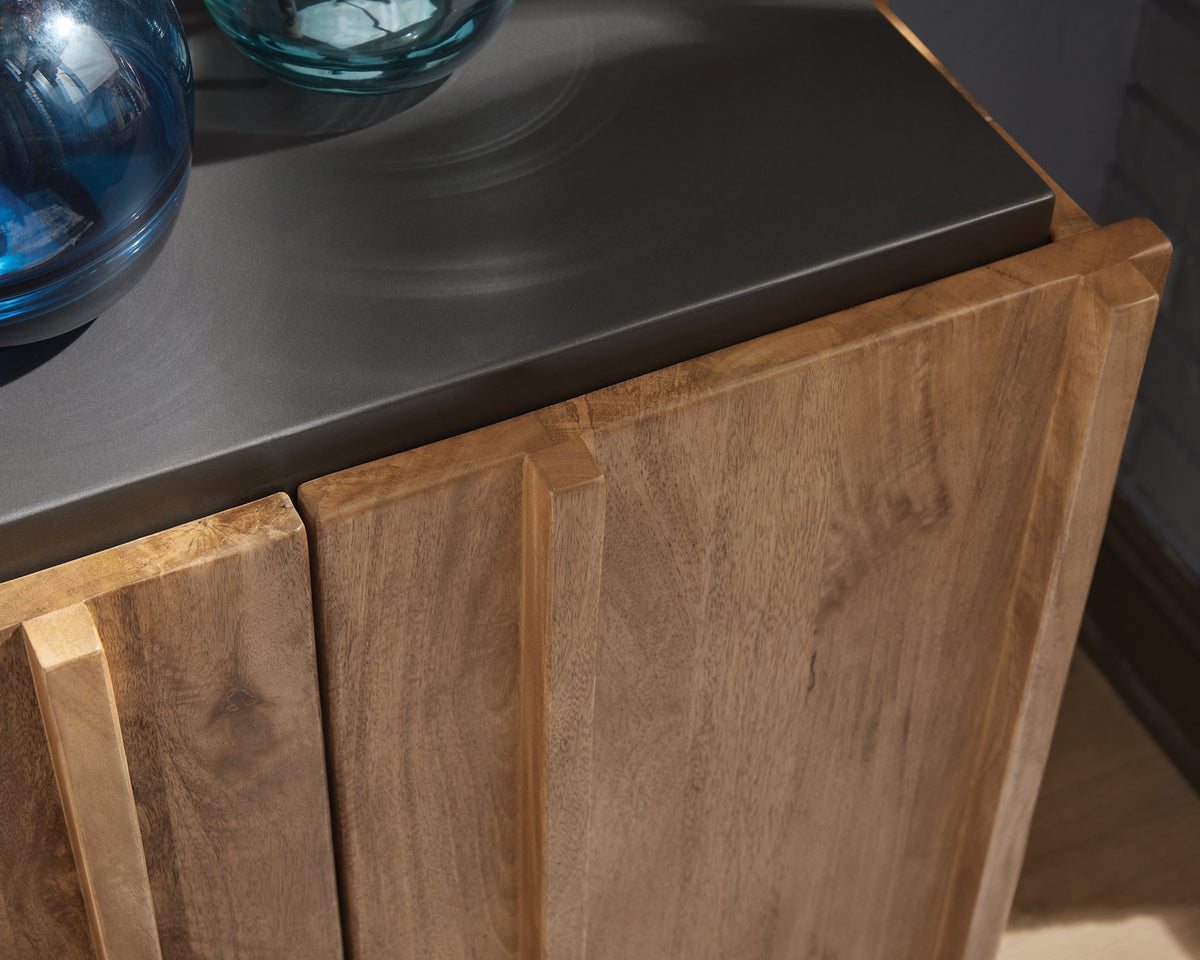 Close-up of the top detail of the Ashley Furniture Quintavious Accent Cabinet showing wood grain and elegant design features.