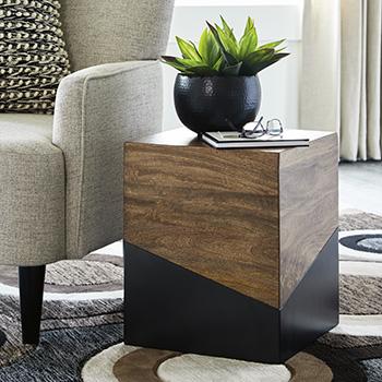 Ashley Furniture Trailbend Accent Table with a round wooden top and metal legs, ideal for living room or bedroom decor.
