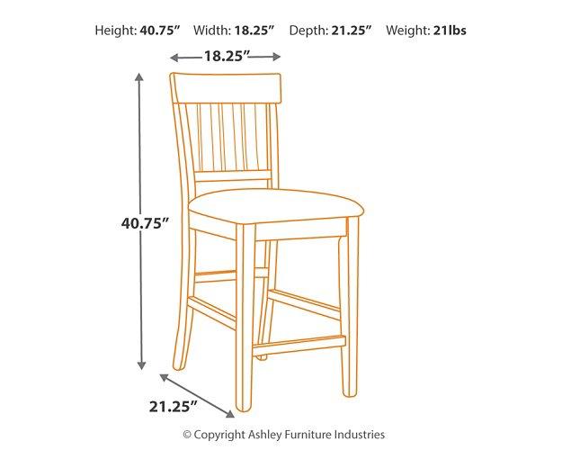 Set of Ashley Furniture Ralene Bar Stools with cushioned seats and wooden legs, arranged around a modern kitchen island.