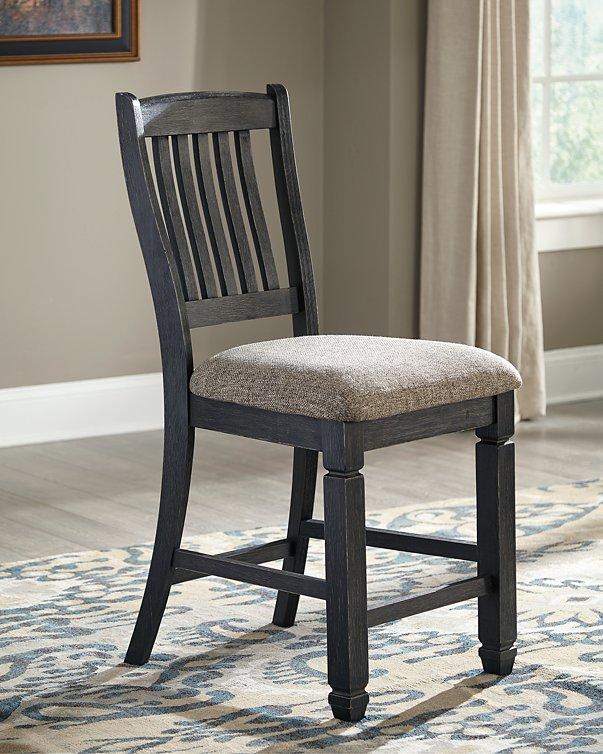 Set of Ashley Furniture Tyler Creek barstools with wooden seats and black metal legs, arranged around a high dining table.
