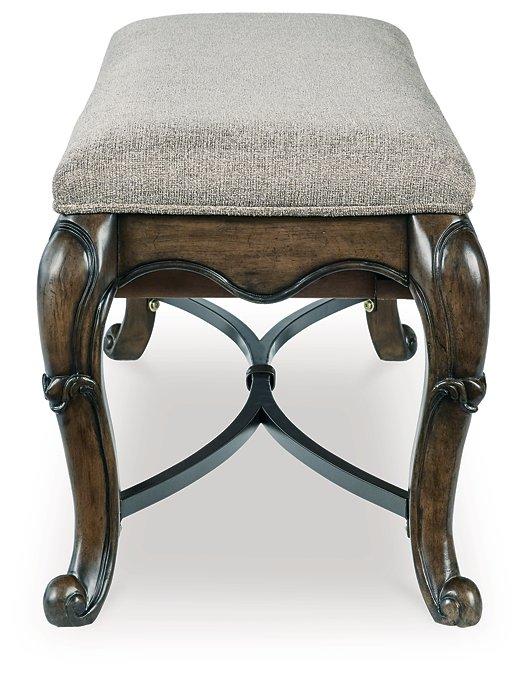 Ashley Furniture Maylee 63-inch wooden dining bench with cushioned seat and sturdy legs, ideal for kitchen or dining room seating.