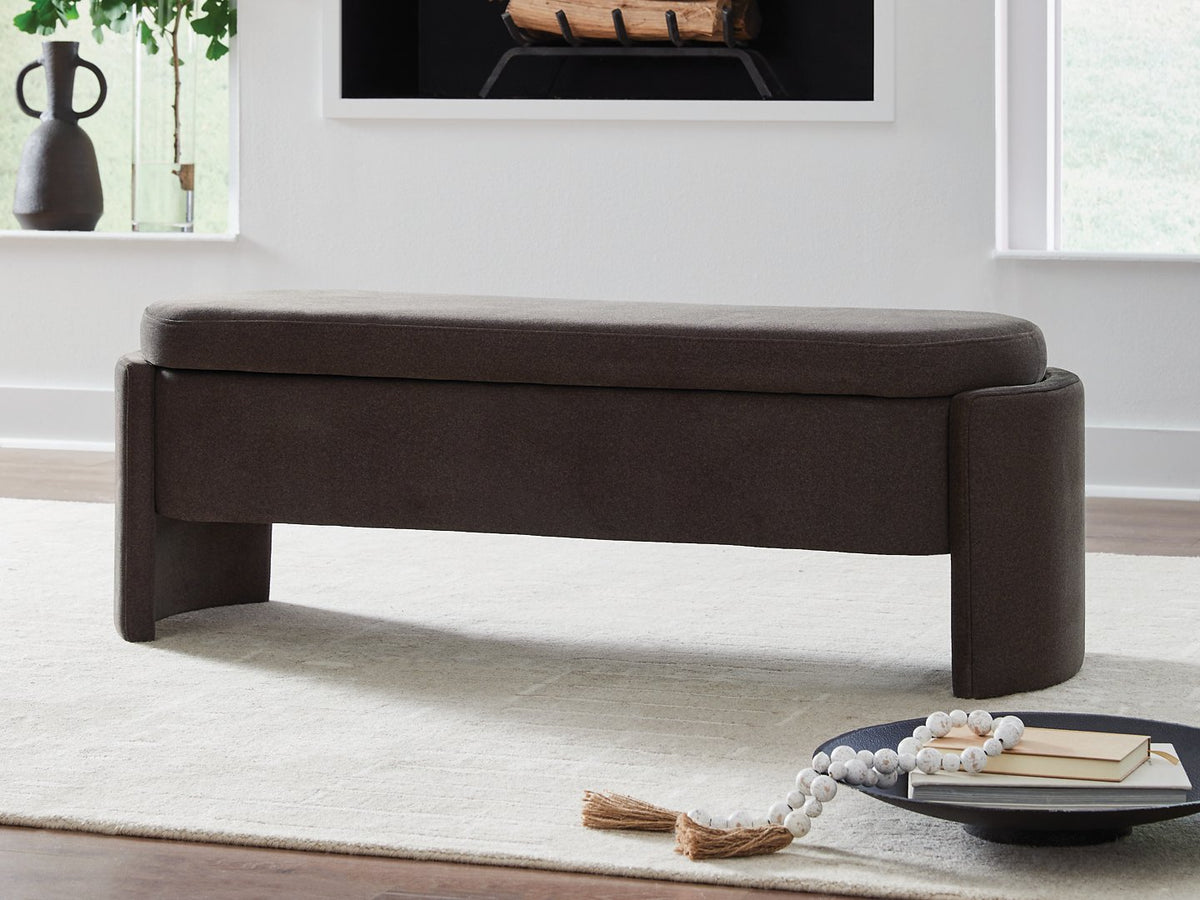 Ashley Furniture Vavuniya storage bench with cushioned top and wooden legs, ideal for entryway or living room storage.