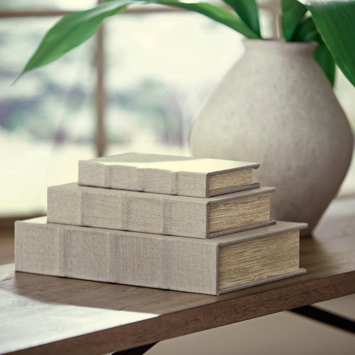 Set of three Jolina storage boxes by Ashley Furniture, featuring wood accents and fabric-lined interiors for organization.