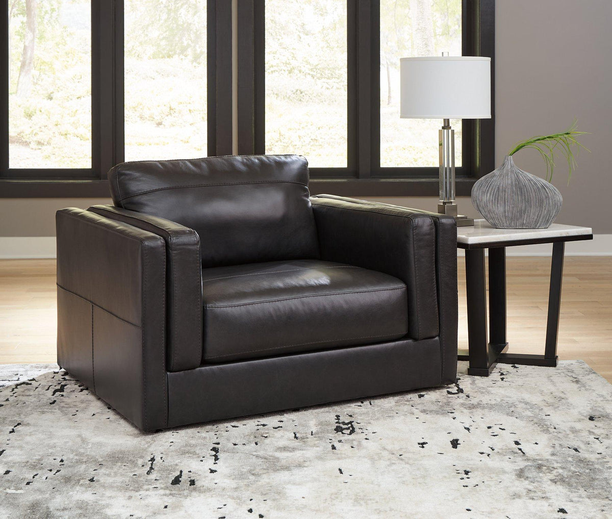 A large Ashley Furniture Amiata Oversized Chair with plush fabric and wide armrests, ideal for comfortable seating in modern living rooms.