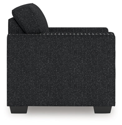 Ashley Furniture Jasmine Peaks Chair showing a side view with a plush upholstered seat and wooden legs.