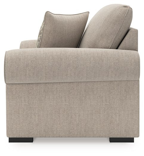 Ashley Furniture Sararose Oversized Chair in beige fabric with plush cushioning and wide armrests, shown from the side.