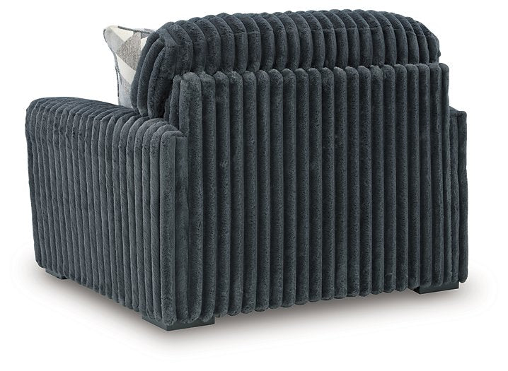 Ashley Furniture Midnight-Madness oversized chair with plush dark fabric and wide armrests, shown from the back in a modern living room setting.