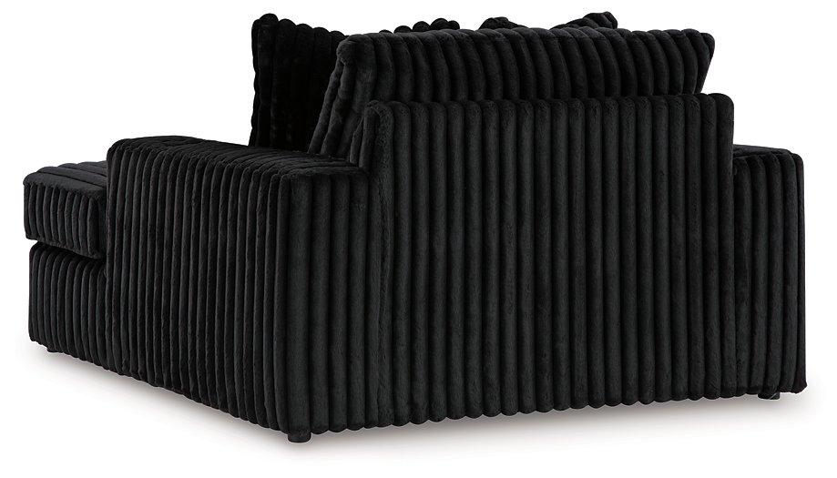 Oversized Ashley Furniture Midnight-Madness chaise lounge with plush fabric and wide seating for relaxing comfort.