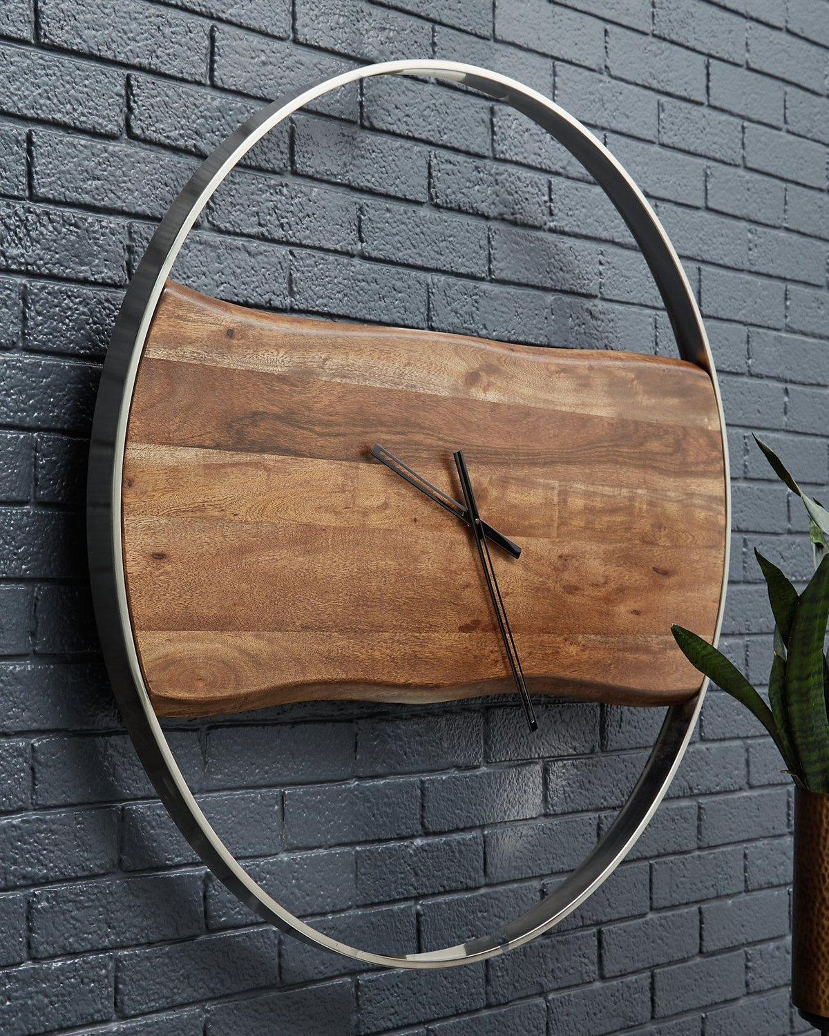 Ashley Furniture Panchali Wall Clock hanging on a wall, featuring a stylish design with a round face and modern clock hands.
