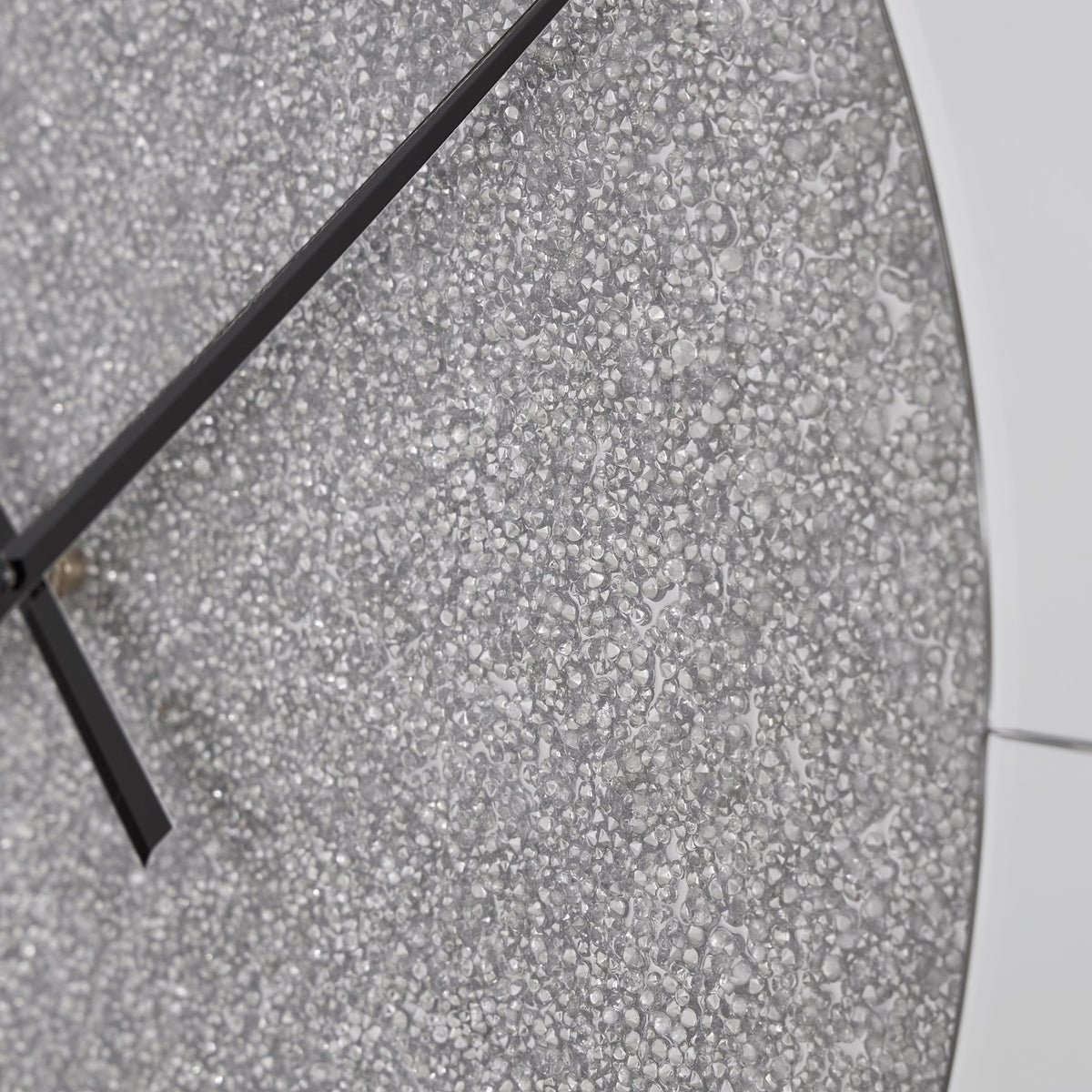 Ashley Furniture Reinport wall clock with a sleek round design and modern numerals, hanging on a neutral-toned wall.