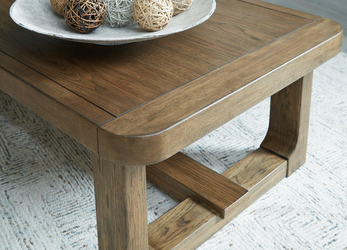 Cabalynn Ashley Furniture cocktail coffee table with wood finish and modern design, placed in a stylish living room setting.