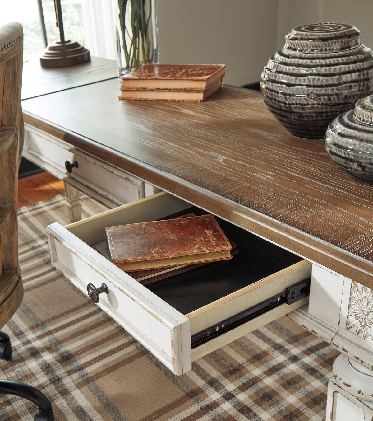 Ashley Furniture Realyn Home Office Lift Top Desk with wood finish, featuring a raised work surface and storage compartments.