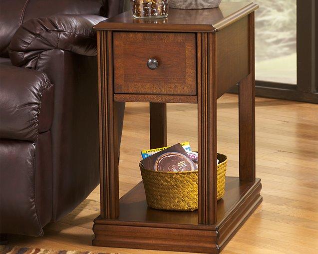 Ashley Furniture Breegin chairside end table with a wood finish, featuring a spacious top and storage shelf in a contemporary design.