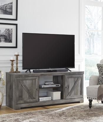 Ashley Furniture Wynnlow 63-inch TV stand entertainment center showing open shelves and storage cabinets in a modern living room setting.