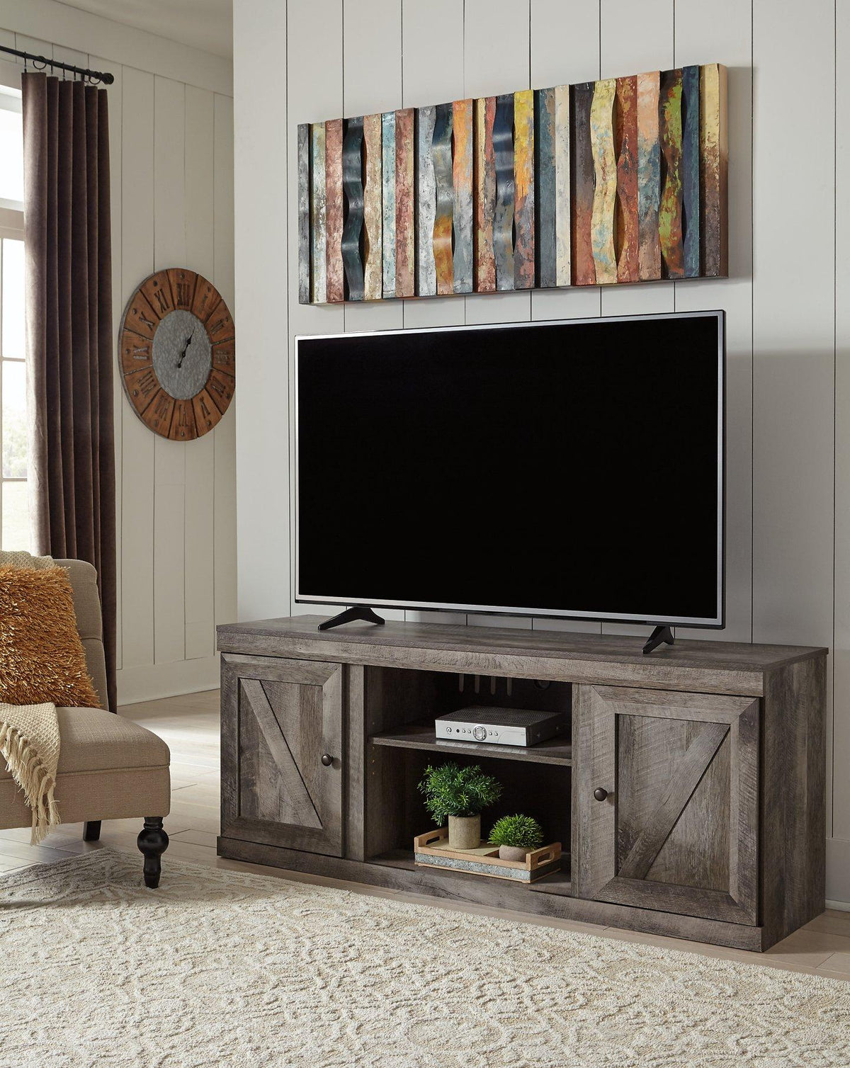 Ashley Wynnlow 4-piece entertainment center with TV stand, cabinets, and shelves in a modern wood finish.