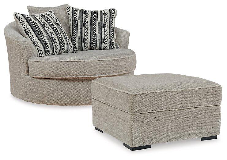Ashley Furniture Calnita living room set with a sofa and armchair, featuring neutral upholstery and modern design elements.
