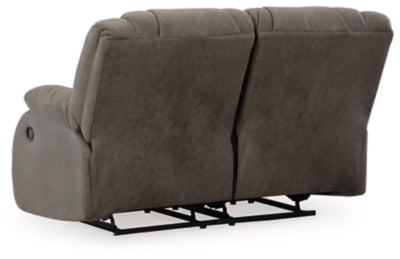 Ashley Furniture First Base reclining loveseat with plush cushions and wide armrests, shown from the back in the image.
