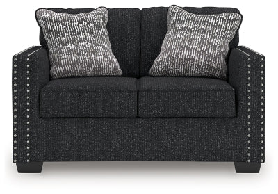 Ashley Furniture Jasmine Peaks loveseat showing plush beige upholstery and cushioned armrests, ideal for cozy living room seating.