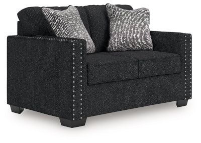 Ashley Furniture Jasmine Peaks loveseat with plush cushions and wooden legs, shown from an angled view.