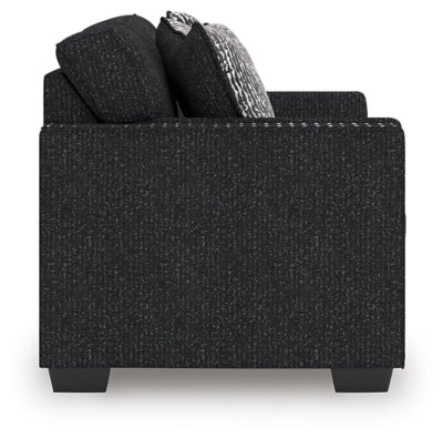 Ashley Furniture Jasmine Peaks loveseat featuring plush fabric and cushioned armrests, shown from a side view.