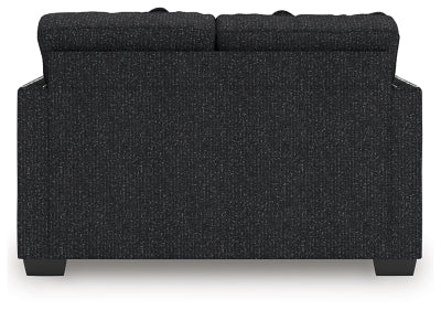 Ashley Furniture Jasmine Peaks loveseat with plush fabric and cushioned backrest, shown in a cozy living room setting.