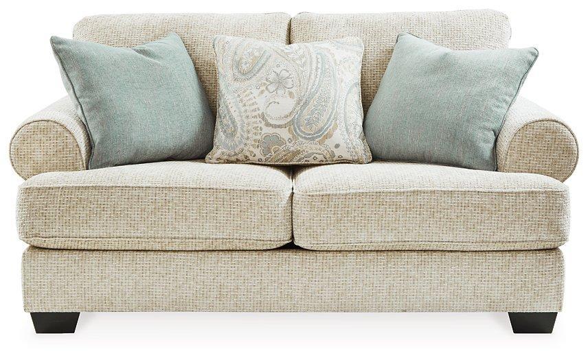 Ashley Furniture Monaghan loveseat with plush upholstery and tufted back in a cozy living room setting.