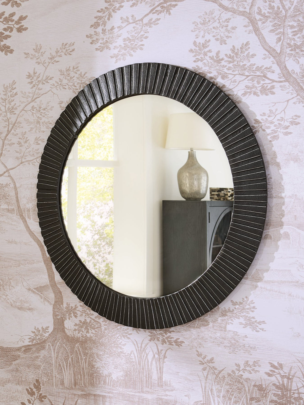 Ashley Furniture Ozias Accent Mirror hanging on a wall with a modern frame, ideal for living room or bedroom decor.