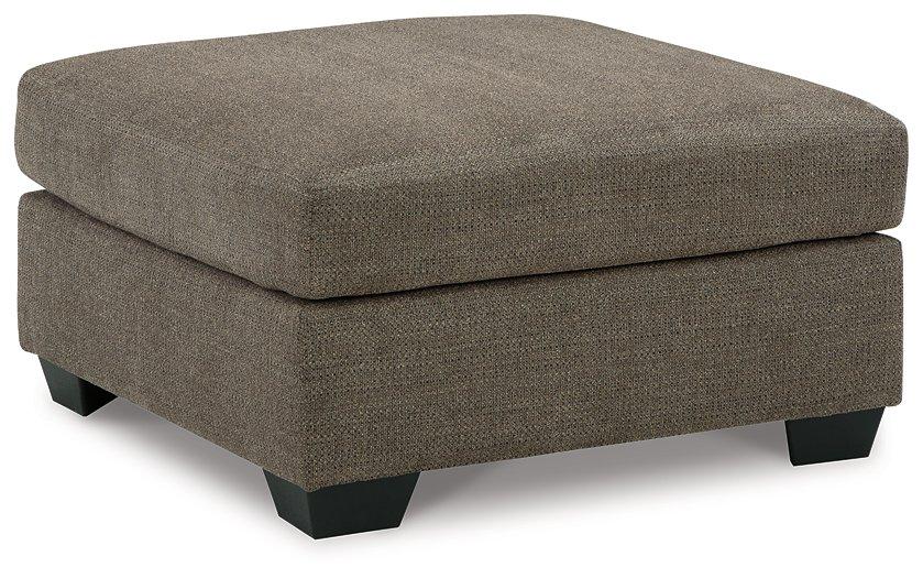 Oversized Ashley Furniture Mahoney accent ottoman with plush fabric and modern design, positioned in a living room setting.
