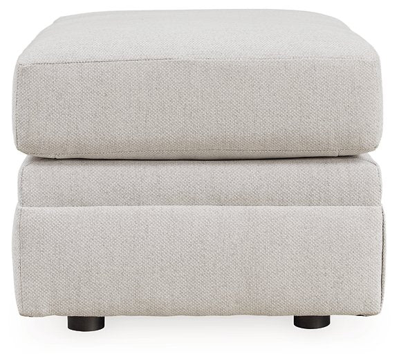 Ashley Furniture Adda Ottoman with cushioned top and wooden legs, serving as a stylish storage or footrest piece.
