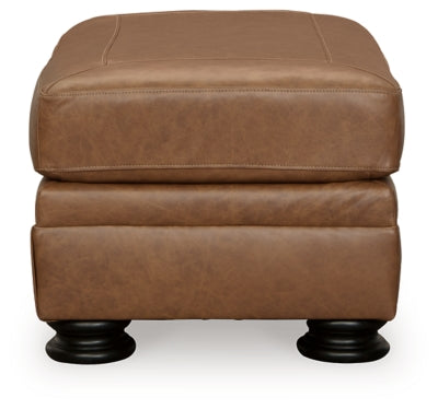 Ashley Furniture Carianna Ottoman in beige fabric, showing a plush cushion and wooden legs on a neutral background.
