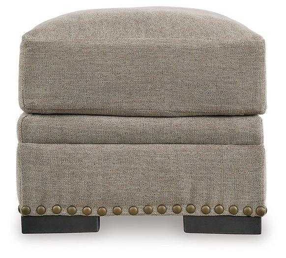 Ashley Furniture Galemore Ottoman with plush fabric and wooden legs, serving as a stylish, functional accent piece in a living room.