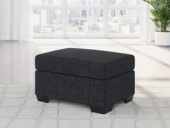 Ashley Furniture Jasmine Peaks Ottoman with plush fabric and wooden legs, showcasing a stylish, versatile ottoman for living rooms.
