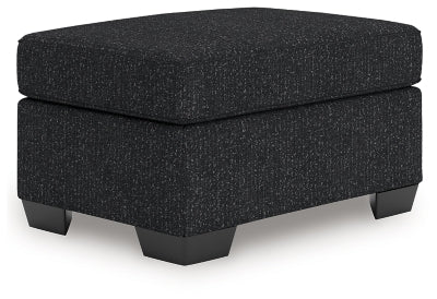 Ashley Furniture Jasmine Peaks Ottoman with plush fabric and wooden legs, shown from an angled view.