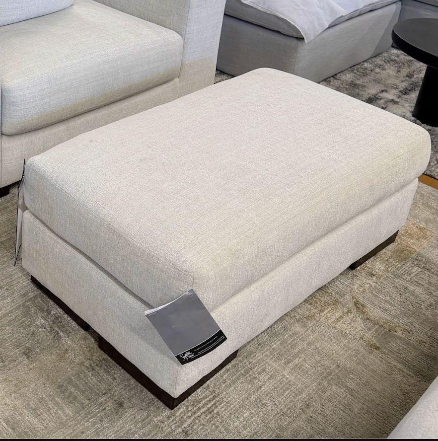 Ashley Furniture Newport Ottoman, plush fabric with tufted top and wooden legs, serving as a stylish accent or footrest.