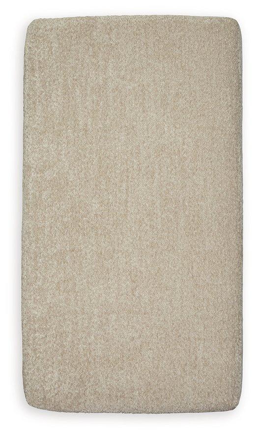 Ashley Furniture Parklynn Ottoman in neutral fabric with wooden legs, showcasing a stylish and functional living room accent piece.