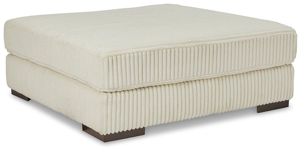 Lindyn oversized accent ottoman by Ashley Furniture with plush fabric and tufted top, serving as a stylish footrest or accent piece.
