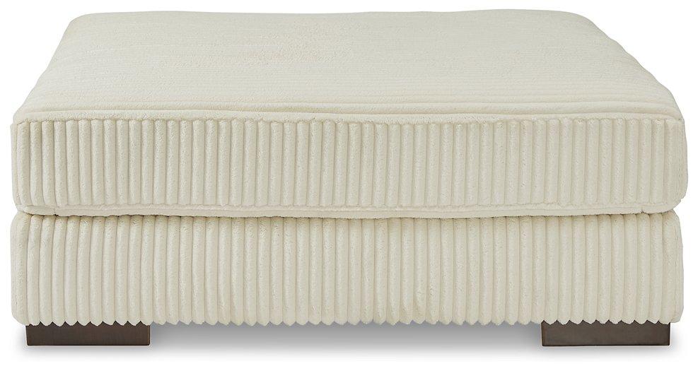 Lindyn oversized accent ottoman by Ashley Furniture featuring plush fabric and sturdy wooden legs in a modern design.