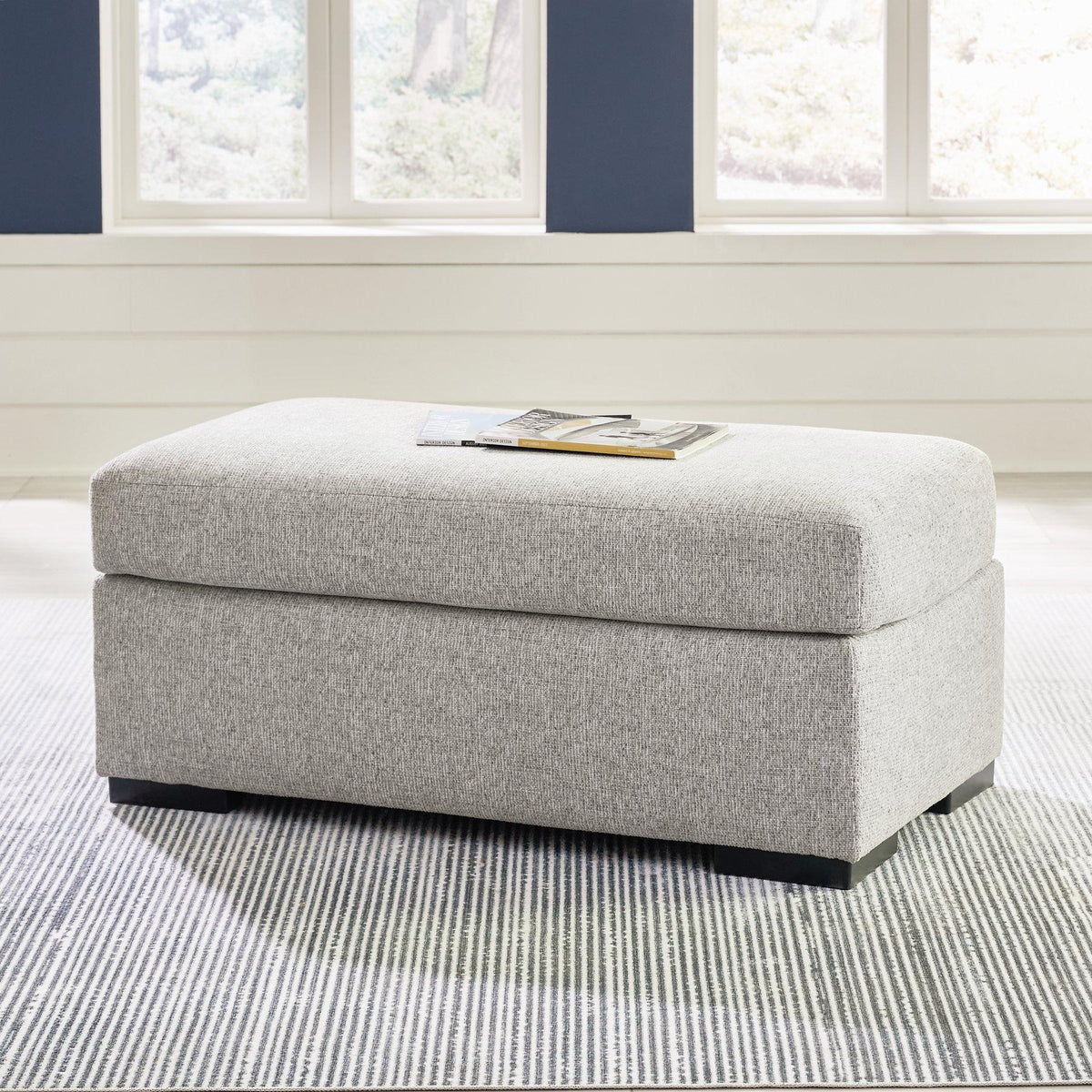 Ashley Furniture Evansley Ottoman with soft fabric upholstery and wooden legs, showcasing a stylish and functional accent piece.
