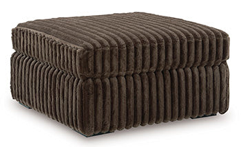 Oversized Ashley Furniture Midnight-Madness accent ottoman with plush fabric and a modern design, shown from an angled view.