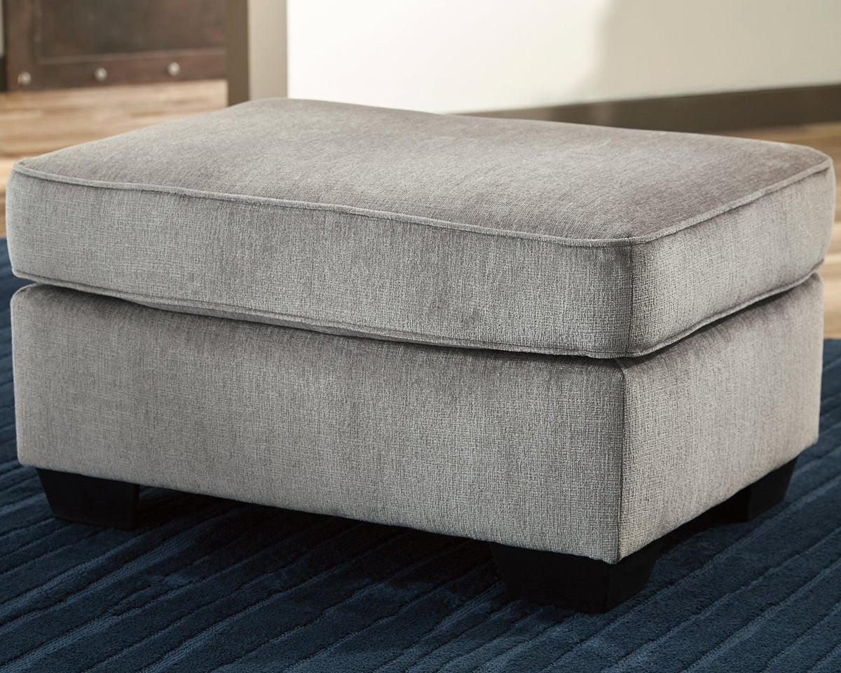 Ashley Furniture Altari Ottoman showing a plush, upholstered ottoman with a neutral fabric finish and stylish wooden legs.