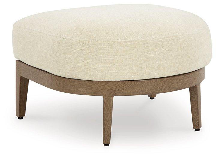 Outdoor Ashley Furniture Serene Bay ottoman with cushion, featuring woven design and plush seating for outdoor relaxation.