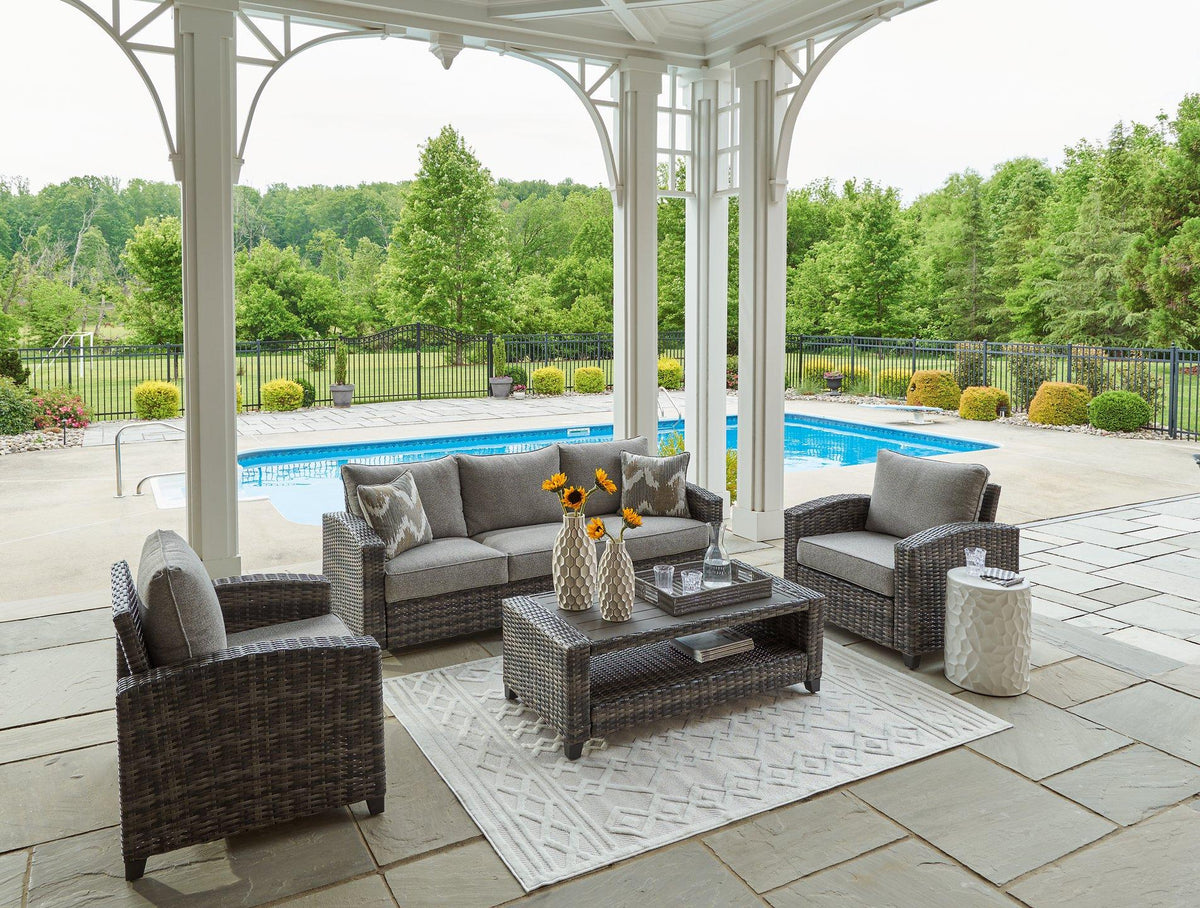 Outdoor patio furniture set by Ashley Furniture, includes sofa, chairs, and table for stylish outdoor seating.