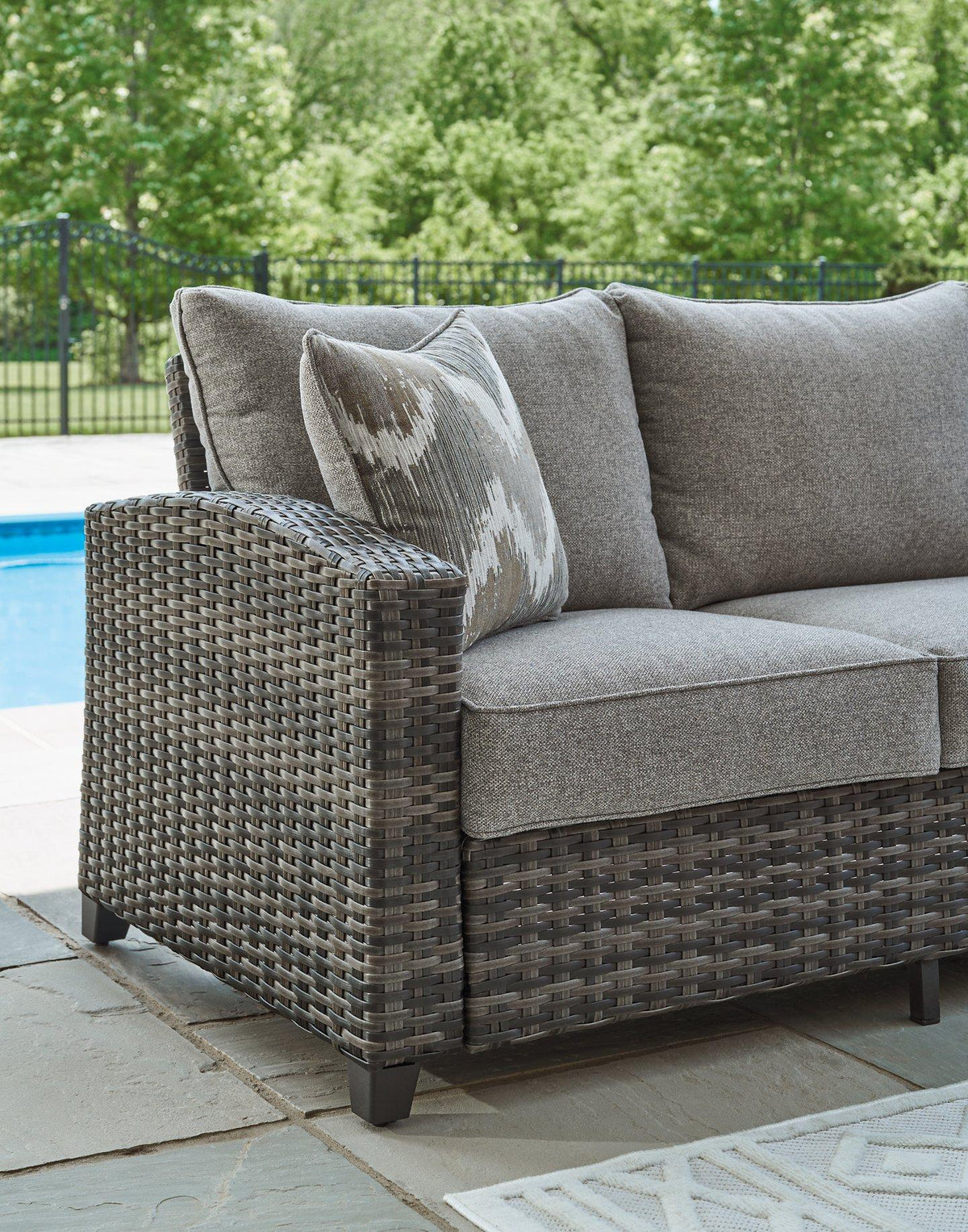Ashley Furniture Oasis Court outdoor sofa, chairs, and table set with cushioned seating and sturdy frame for patio relaxation.