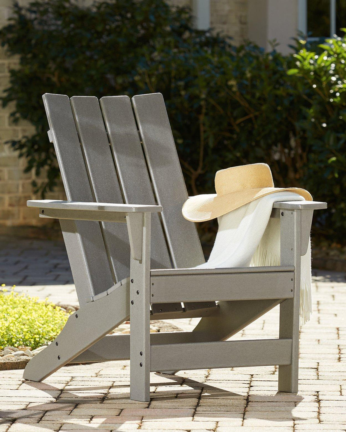 Ashley Furniture Visola outdoor Adirondack chair with matching end table in a cozy outdoor seating set.